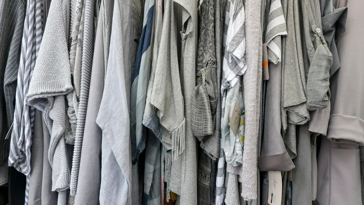 ハンガーに並ぶグレーや白の服