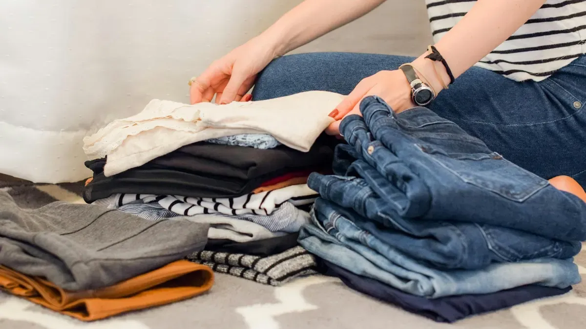手持ちの服をたたんで見直している様子