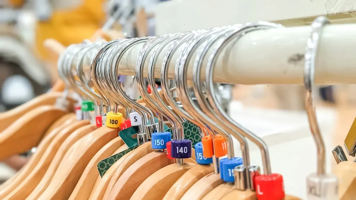 サイズの札が付いた木製のハンガー