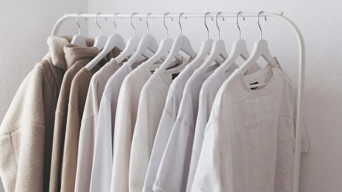 ハンガーにかけた白やベージュの服