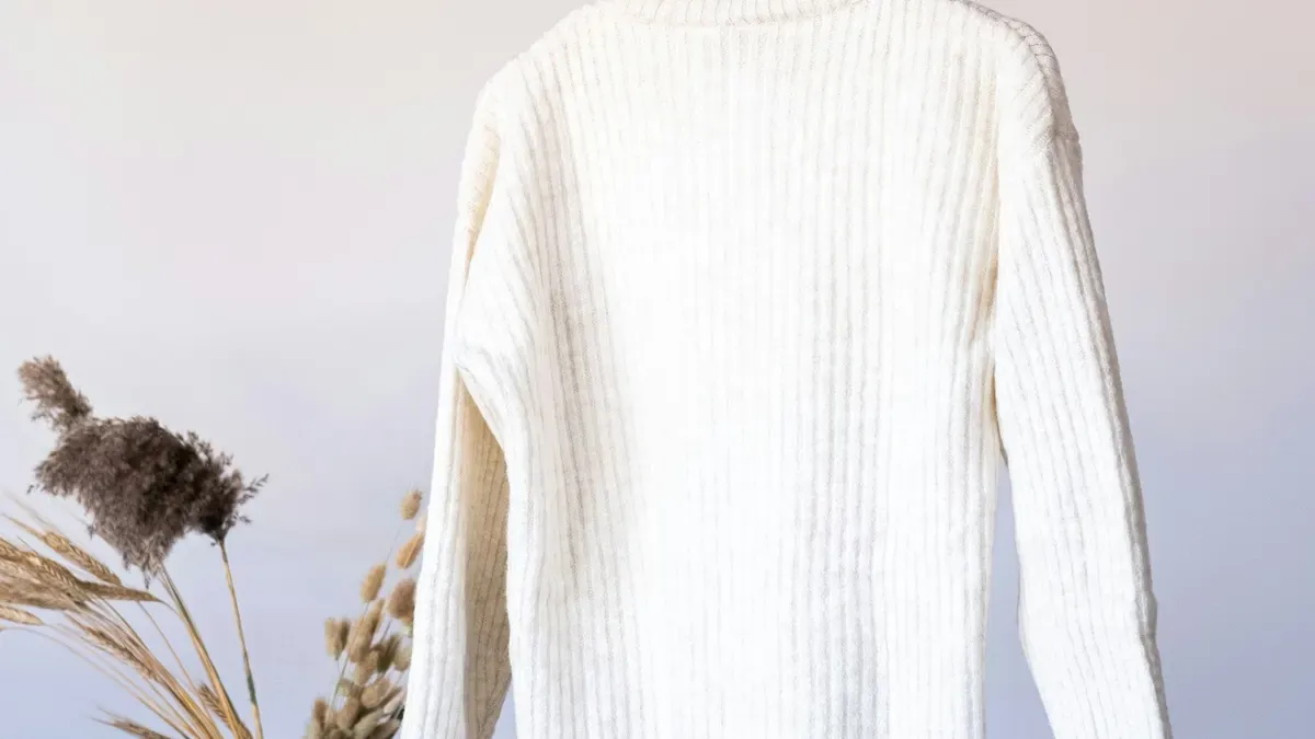 ハンガーにかけたアイボリーのニット