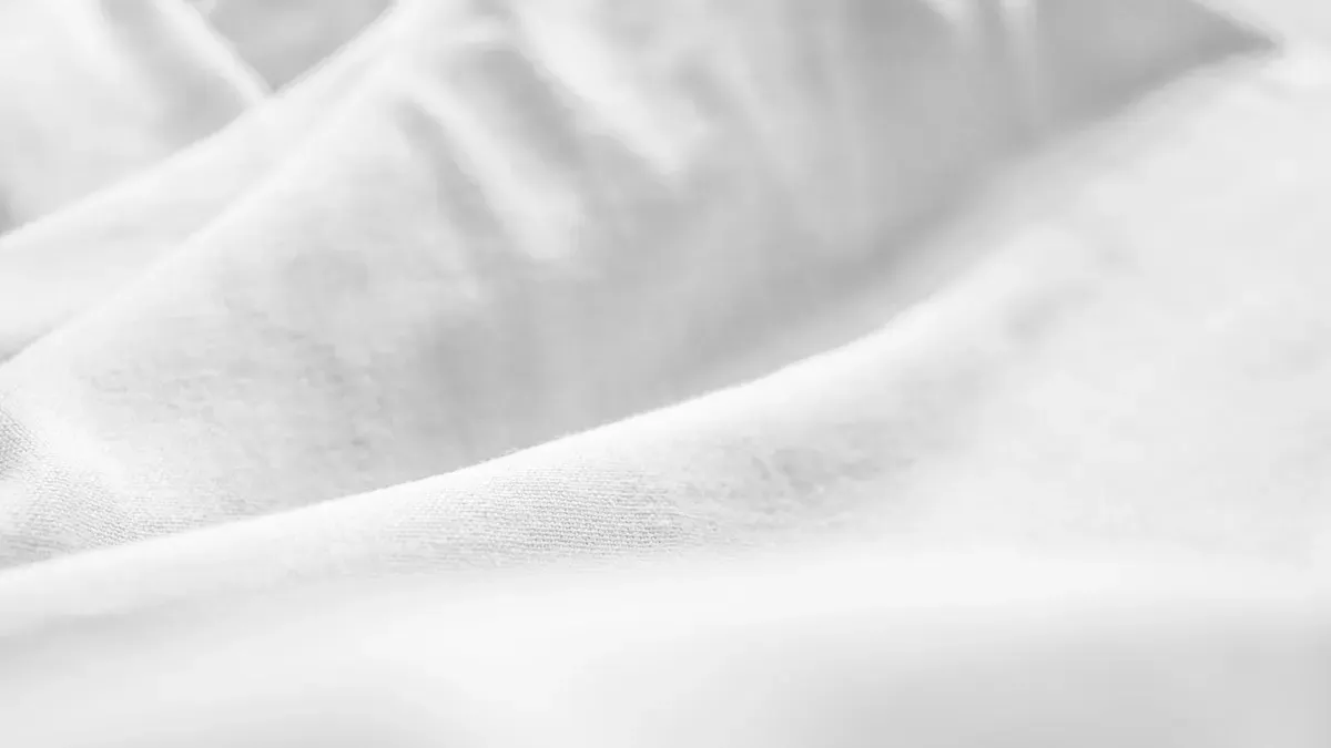 自分に似合う色の服を顔まわりに当てて選ぶ女性